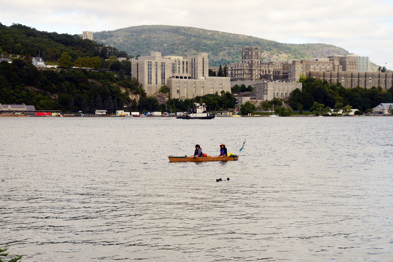 Members of the Sea Change Flotilla in a paper boat on the Hudson river in front of West Point Military Academy. Photo by Ellen Davidson.